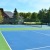 a tennis court with a house in the background